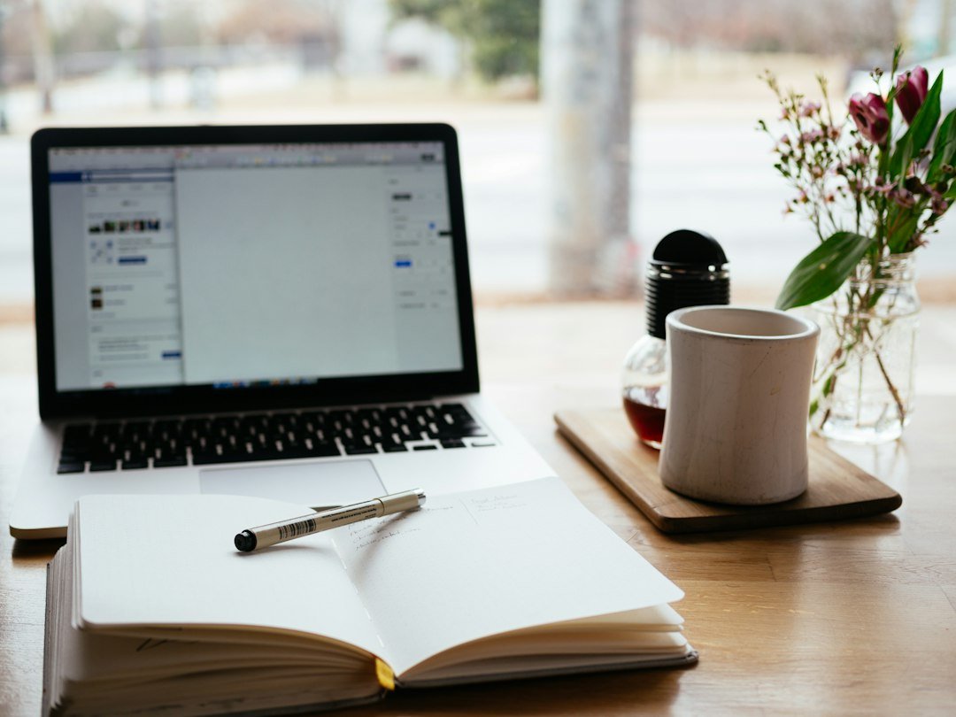 Laptop and notepad on a desk for planning application materials.